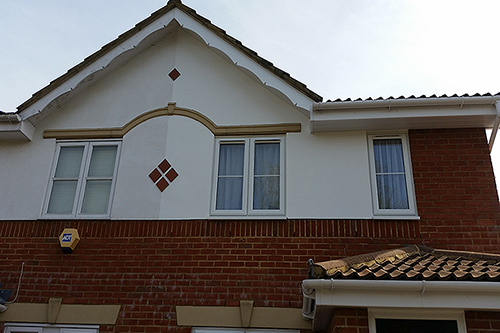 Exterior decoration to the front of house including the walls, 2 coats of exterior masonry paint, and decorative gable end, primed undercoat and a white gloss finish