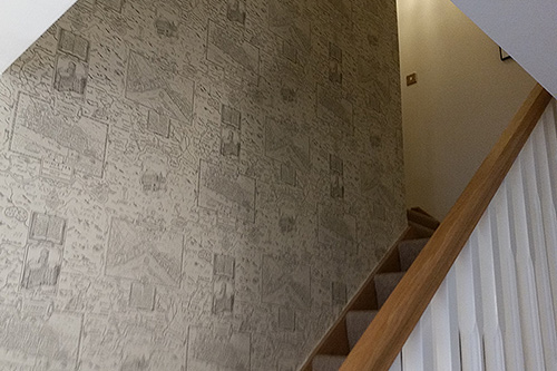 Staircase featuring designer wallpaper