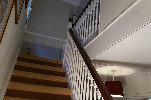 Interior decoration of staircase turning the spindles from a dark brown finish to a interior designed eggshell finish