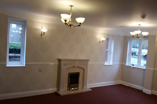Residential communal lounge with featured fireplace wall with Laura Ashley wallpaper; walls in Farrow & Ball - works completed