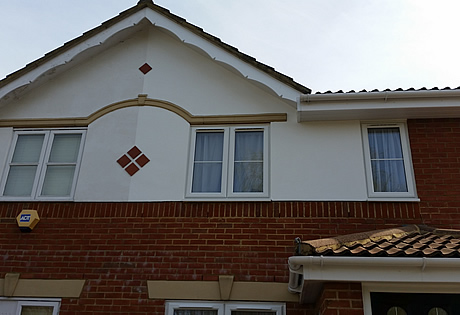 Exterior decoration to the front of house including the walls, 2 coats of exterior masonry paint, and decorative gable end, primed undercoat and a white gloss finish.