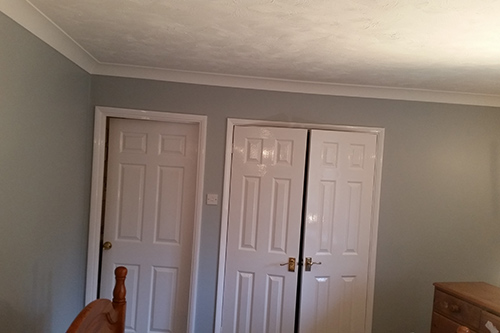 Room with six panel door with gloss finish and designer wallpaper